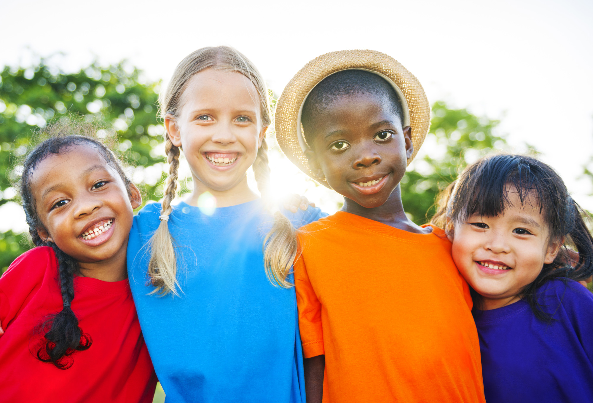 group of smiling children outside in summer